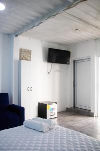 AtitancitoPacífico Cielo Eco Hotel的卧室配有一张床,墙上配有电视。