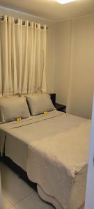 巴西利亚The Sun Resort - Super Apartamento de 2 quartos - 1 suíte e 1 reversível的一间卧室配有一张带白色床单的床和一扇窗户。