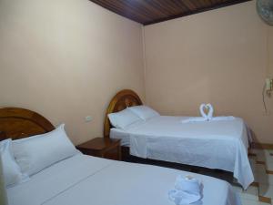 廷戈玛丽亚Hostal Ucayali的酒店客房,配有两张带白色床单的床