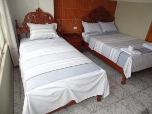 廷戈玛丽亚Hostal Ucayali的两张睡床彼此相邻,位于一个房间里