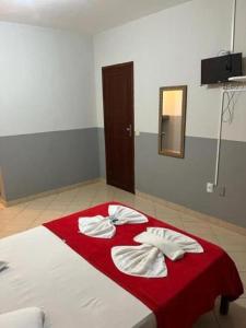 瓜拉派瑞Pousada Paraiso Guarapari的一间卧室配有一张带红色毯子和镜子的床