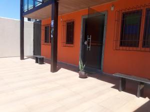 瓜拉派瑞Pousada Paraiso Guarapari的一座带橙色墙壁的建筑,有门和植物