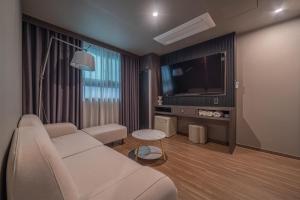 庆州Gyeongju Poverta Hotel的客厅配有白色沙发和电视