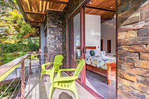 蒙泰韦尔德哥斯达黎加Cougar Monteverde的一个带两把绿色椅子的庭院和一间卧室