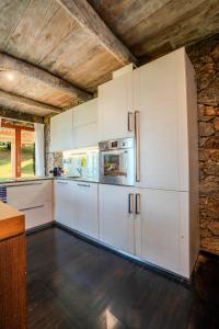KalawanaJml villa foresta的厨房配有白色橱柜和冰箱。