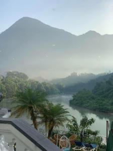 河江Phoenix Hotel Hà Giang的享有棕榈树和山脉的河流美景