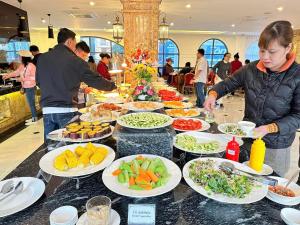 河江Phoenix Hotel Hà Giang的餐桌上的自助餐,包括盘子