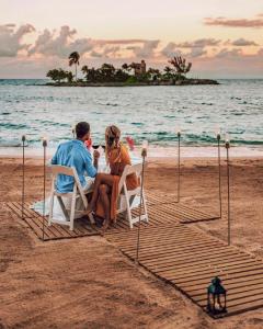 普拉亚布兰卡ABBY TOURISM的坐在沙滩椅上的男人和女人