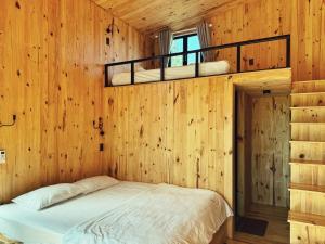 波来古市XOM Organic Farm Stay的卧室配有木墙内的一张床