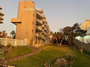 巴利托Beachfront apartment in Ballito! Casablanca的一座建筑旁边设有草地庭院的建筑