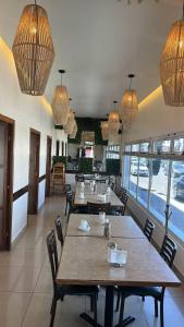 CuauhtémocTarahumara Inn的餐厅设有桌椅和吊灯。