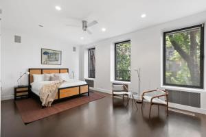 纽约Chelsea Canvas II by RoveTravel Large 3BR Duplex的一间卧室配有一张床、两把椅子和窗户