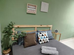 哥打巴鲁Suite Us Guesthouse Kubang Kerian的一间卧室配有带枕头和植物的床