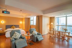 江门江门绿岛假日酒店的酒店客房,配有一张床和两把椅子