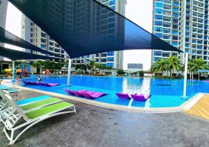 马六甲Atlantis Residences Melaka by Be My Guest Management的大楼内带躺椅的大型游泳池