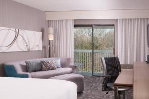 格林维尔格林维尔斯巴坦堡机场万怡酒店的酒店客房配有床、沙发和桌子。