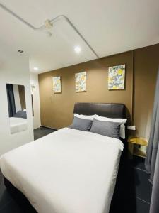Wakaf BaharuHalo Rooms Hotel的卧室配有一张带两个枕头的大白色床