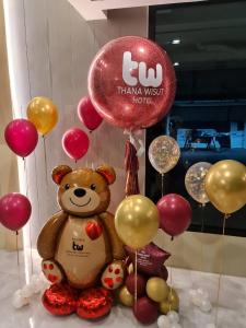 曼谷Thana Wisut Hotel - SHA Plus的坐在一束气球旁的泰迪熊
