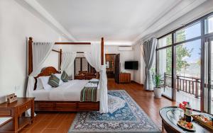琅勃拉邦Relaxful Hotel泊岸酒店的一间卧室设有一张天蓬床和一个阳台