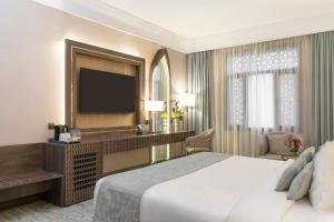 麦地那دار الإيمان الحرم - Dar Aleiman Al Haram的配有一张床和一台平面电视的酒店客房