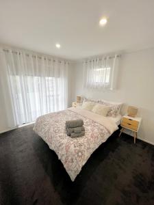 奥克兰New Lynn Dream guest house的白色的卧室设有一张大床和一个窗户