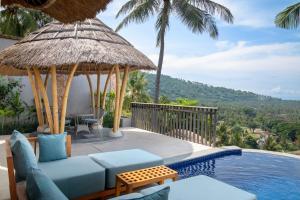 圣吉吉Kalandara Resort Lombok的别墅 - 带一个带蓝色沙发的游泳池