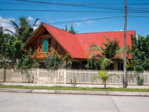 奥克萨潘帕Hospedaje Cattleya的一座红色屋顶和白色围栏的房子