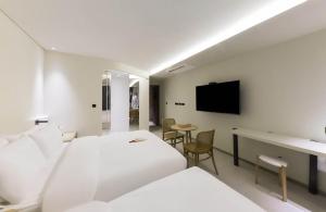 釜山MUTE HOTEL的酒店客房设有一张床、一张书桌和一台电视机。
