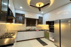 海得拉巴Brand New Luxurious Independent Villa的厨房配有白色橱柜和吊扇