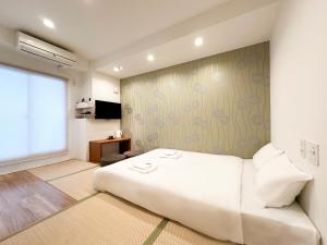 大阪大阪惠比寿酒店的卧室设有一张白色大床和一扇窗户。