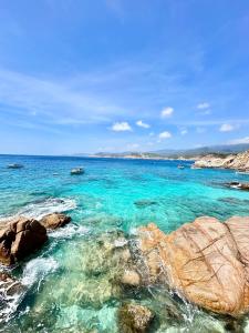 永熙THUẬN VƯƠNG Homestay的一片清澈 ⁇ 蓝的海水和岩石海滩