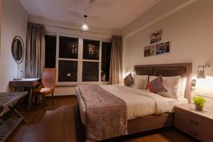 尼禄Carnival De Goa的配有一张床、一张书桌和一扇窗户的酒店客房