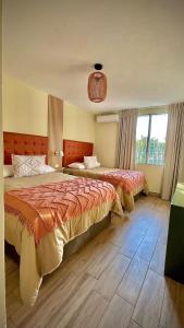 危地马拉In & Out Hotel的一间卧室设有两张床和大窗户
