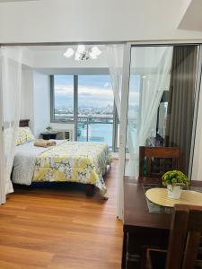 马尼拉Azure Staycation Place的一间卧室配有一张床、一张桌子和一个窗户。