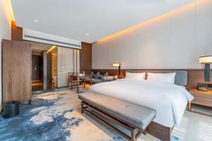 济南Jinan Ziyue Meixiu Hotel的一间带大床的卧室和一间客厅