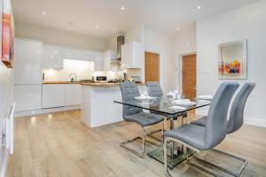 梅登黑德Luxury Apartments 2 Bedrooms Central Maidenhead的厨房以及带桌椅的用餐室。