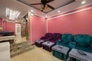 河内Hanoi Backpackers Hostel Oldtown的客厅设有粉红色的墙壁和紫色的家具