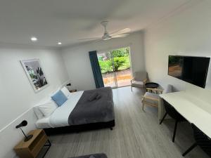 马里巴Mareeba Motor Inn的一间卧室配有一张床、一张书桌和一台电视
