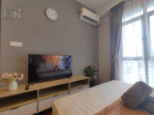 哥打京那巴鲁K Avenue Modern Style Studio (5 Mins to Airport)的一间卧室配有一张床、一台电视和一部时钟