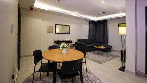 科威特Saray Hotel Apartments的客厅配有桌子和沙发