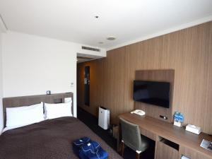 佐世保佐世保阳西酒店的酒店客房配有一张床和一张书桌及一台电视