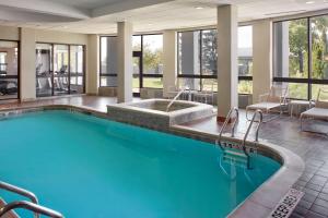 米西索加密西沙加机场企业中心西万怡酒店的酒店大堂的大型游泳池配有桌椅