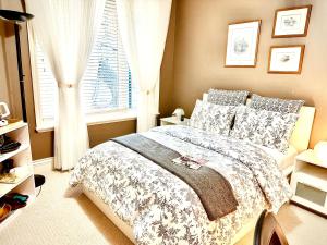 Pitt MeadowsLangley独立洗手间的一楼温馨客房的一间卧室设有一张大床和一个窗户。