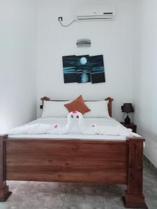 尼甘布Negombo Royal Villa by Hotel Oviniru的一间卧室配有一张大木床和白色床单