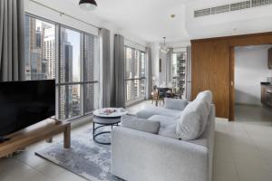 迪拜Class Home-Superb 1BR apartment with full Burj Khalifa View-5min walk to Dubai Mall的带沙发和电视的客厅