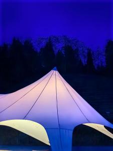 张家界Zhangjiajie National Forest Park Camping的夜间亮起一个白色的大帐篷
