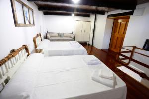 FolgosoA CASA DO POZO的配有白色床单的客房内的两张床