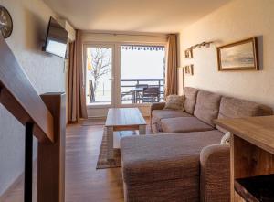 奈达Curonian apartments的客厅配有沙发和桌子
