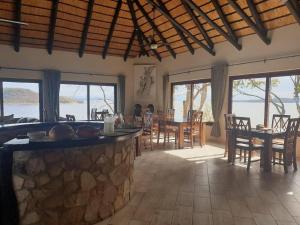 BingaMasumu River Lodge的用餐室设有桌椅和窗户。