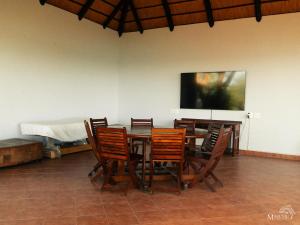 BingaMasumu River Lodge的用餐室配有桌椅和平面电视。
